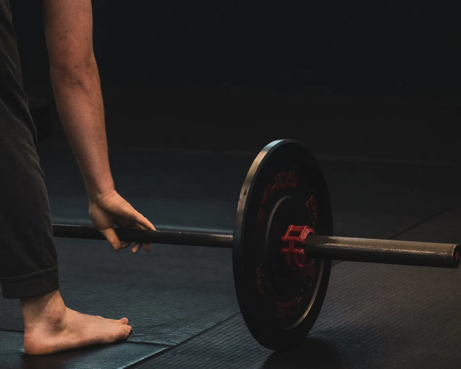 a lifter setting their grip on a loaded barbell