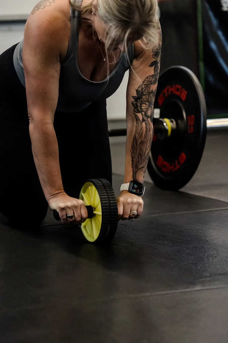 a member rolling out on an ab wheel, close crop