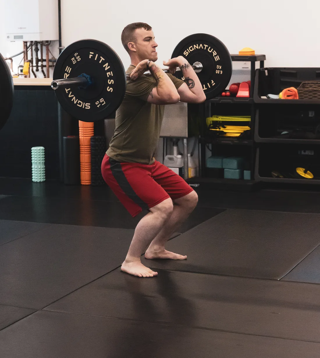 a member holding a barbell in the front-rack position