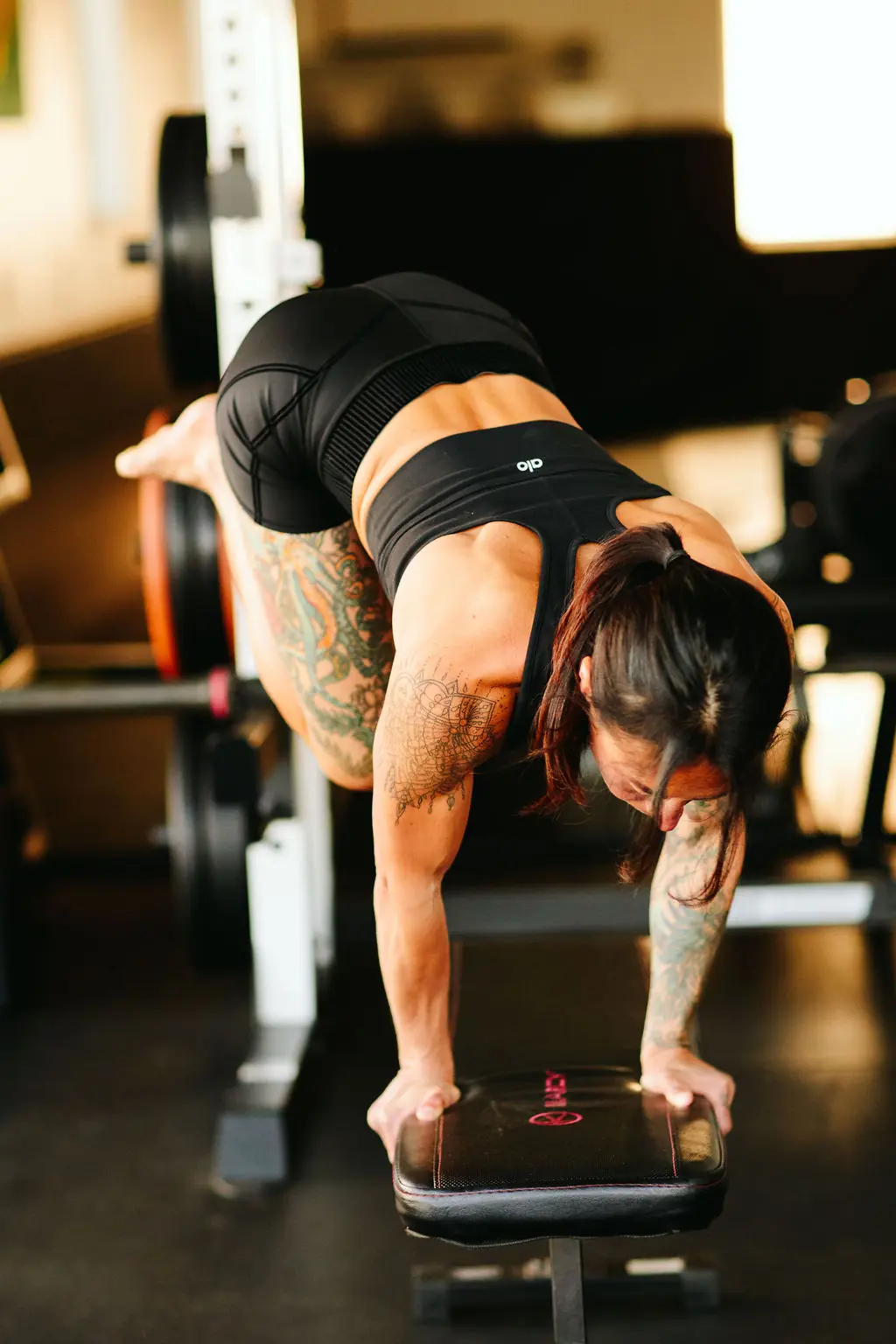 a member holding an elevated plank on a bench