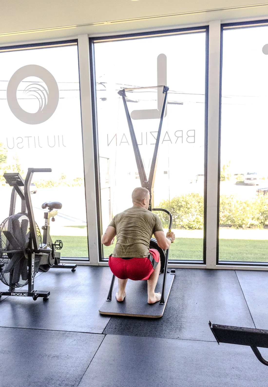 a member working the ski erg beside the gym&rsquo;s front windows