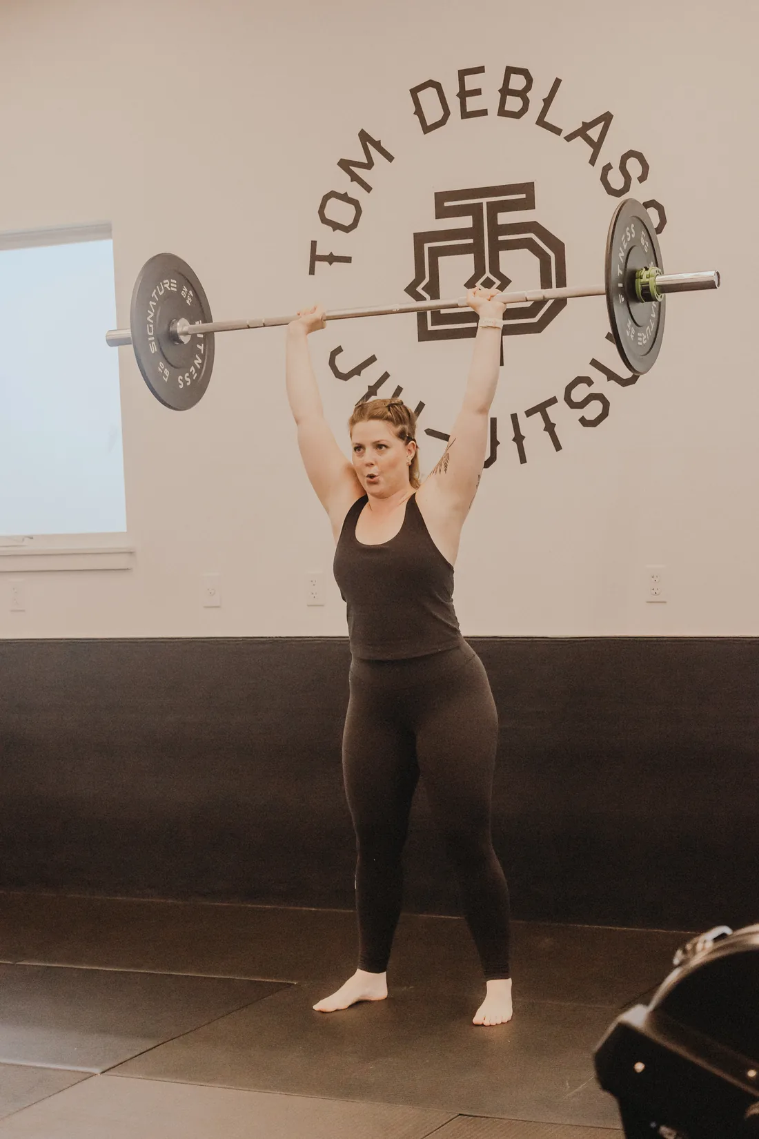 a member pressing a barbell overhead