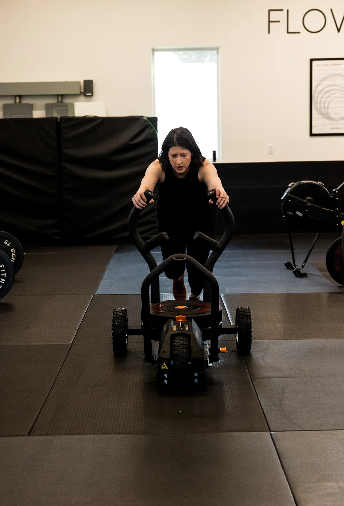 a member driving a weighted sled across the floor