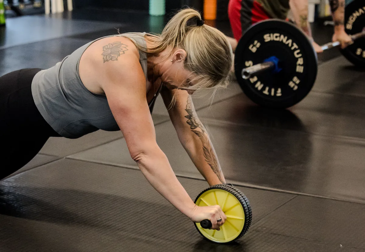 a member rolling out on an ab wheel