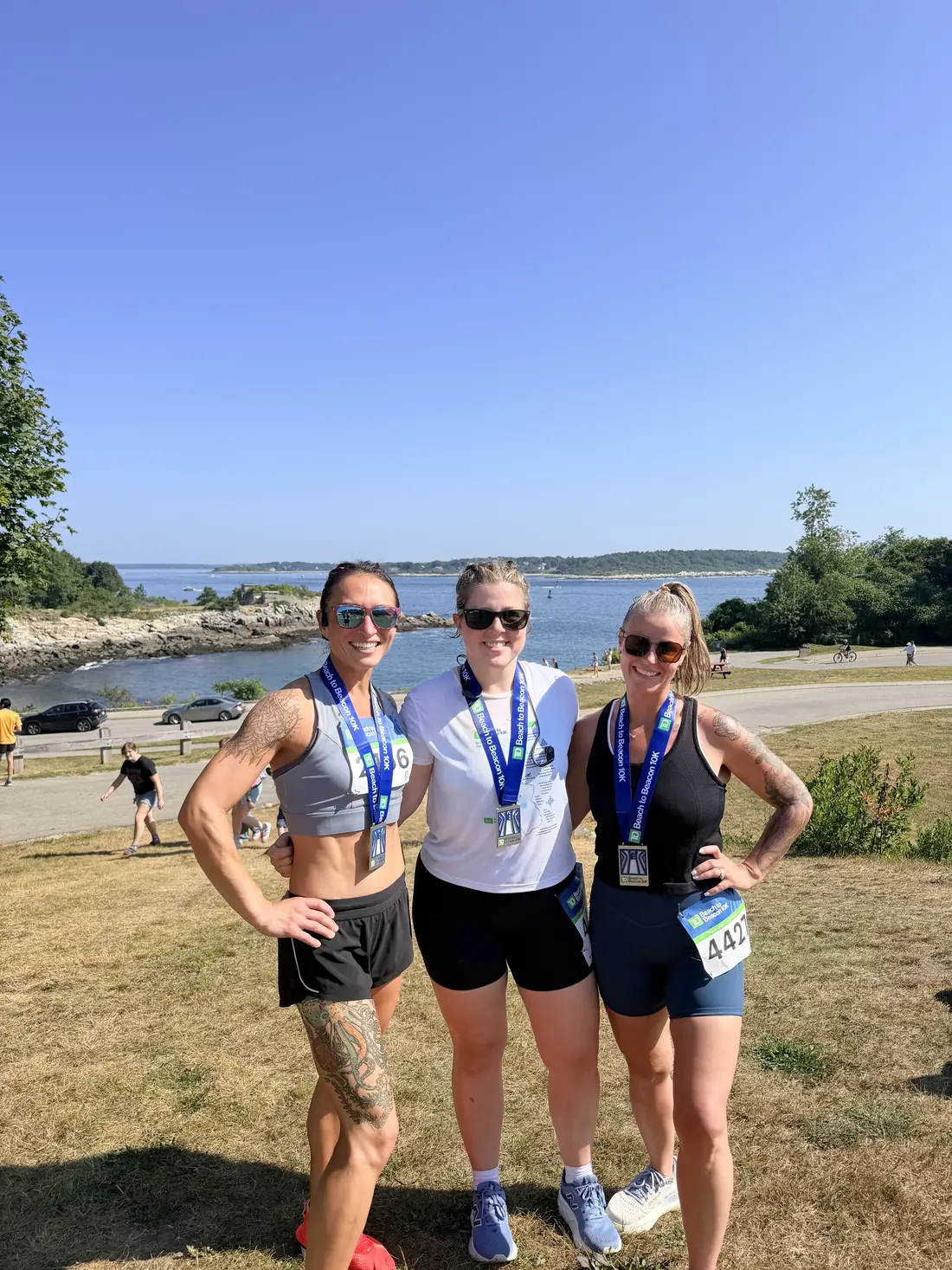 Sandy Martz with two training partners and their medals after the TD Beach to Beacon 10K
